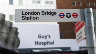 London Bridge station sign, with Guy's Hospital main entrance in background.