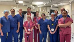 Large group photo of surgical team, wearing scrubs, who performed the UK-first procedure.