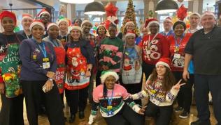 Catering team at St Thomas' Hospital smiling for a group photo. They are wearing Christmas hats and jumpers. 