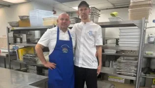 Chef Ned and Scott in chef whites, standing in St Thomas' kitchen.