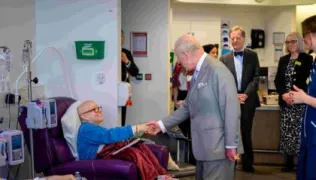 The King meeting a patient who is receiving chemotherapy treatment
