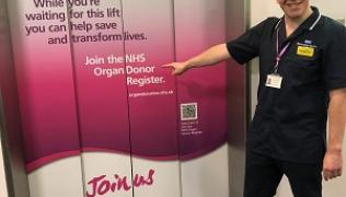 Healthcare worker pointing at new organ donation lift wraps