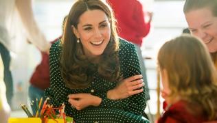 Duchess of Cambridge talking to a child while visiting Evelina London