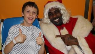 Idris Elba dressed as Father Christmas with patient Ryan Carter