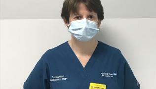 Dr Katherine Henderson is wearing blue scrubs and a face mask