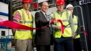 MP Simon Hughes, with local apprentices in high-vis tops and hard hats, cutting a ribbon to launch the Guy's Tower re-cladding scheme.
