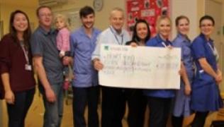 Victoria with staff from Savannah Ward holding a giant cheque