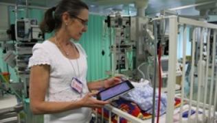 A doctor uses an i-pad in PICU
