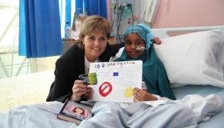 Chief Nurse Dame Eileen Sills congratulates poster competition winner Khadija Hussein
