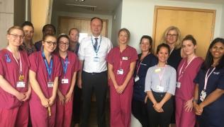 NHS England chief executive posing with midwives