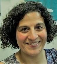 Tania Kalsi, Consultant in Geriatric and General Internal Medicine, Woman with curly black hair.