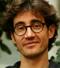 Tommaso Donati is a man with wavy brown hair and glasses