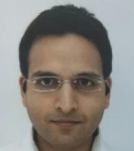 Satinder Chander is a man with short black hair and glasses