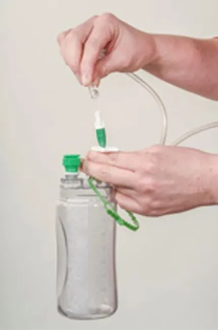 A close-up of hands putting the tube onto a new empty bottle