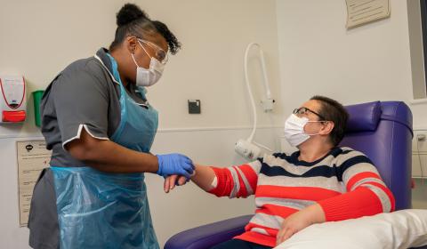 Nurse preparing patient's hand for treatment