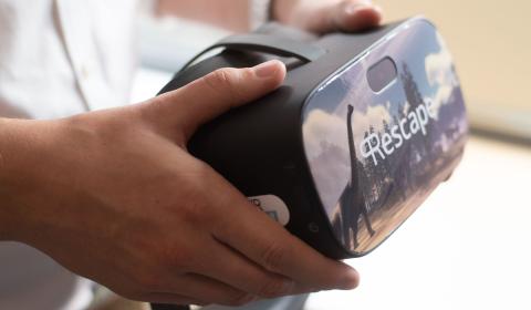 A close up of a person holding a VR headset