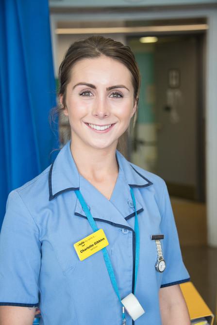 Staff nurse wearing a light blue uniform.