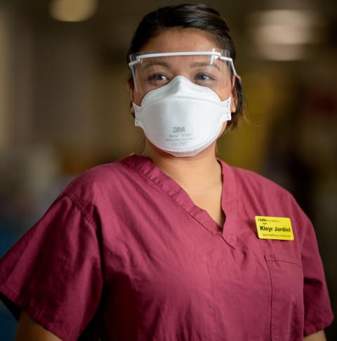 Kleyr Jardiel, staff nurse, wearing maroon scrubs, PPE eyewear and mask during the COVID-19 pandemic