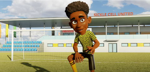 An image from an animation with a boy in a football stadium marked Sickle Cell United. The boy is on the pitch and wears a yellow top with a black pattern, black shorts and and yellow long socks. Behind him is a goal and the seating area for fans.