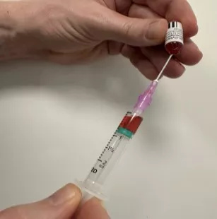 Hand-drawing showing how to draw up vitamin B12 for intramuscular injection with needle and syringe alignment