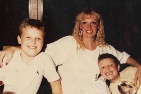 A family photo of Gary with his older brother and mum. They are all smiling. 