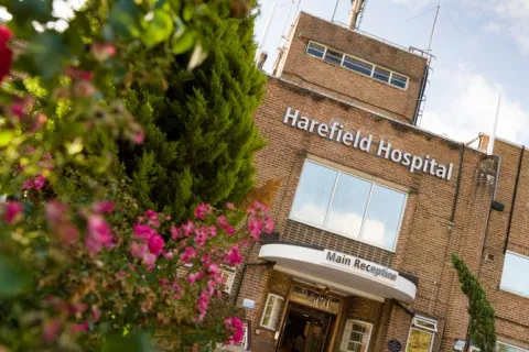 Harefield Hospital main entrance, with a rose shrub in the foreground