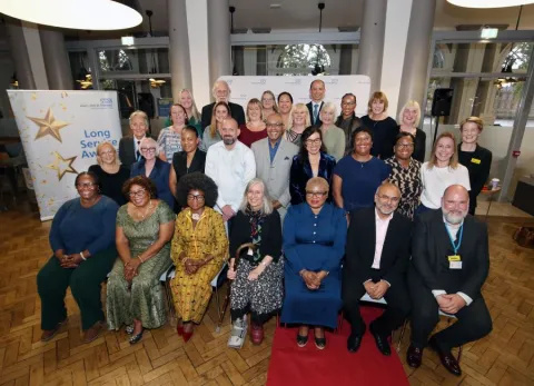 Large group photo of Long Service Award winners seated and standing in Shepherd Hall