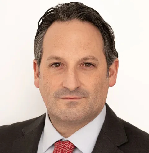 Headshot of Lorenzo Garagnani, who is wearing a dark suit jacket, white shirt and red tie. He has dark hair.