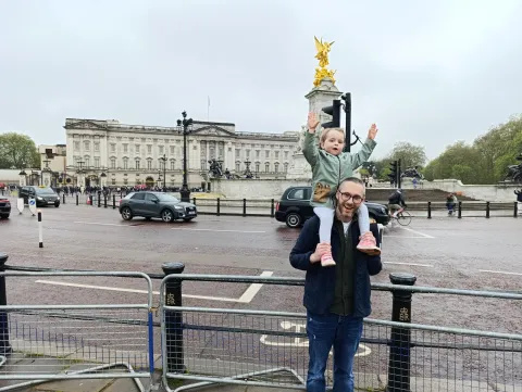 Luna on Stuart's shoulders as they stand in front of Buckingham Palace. 