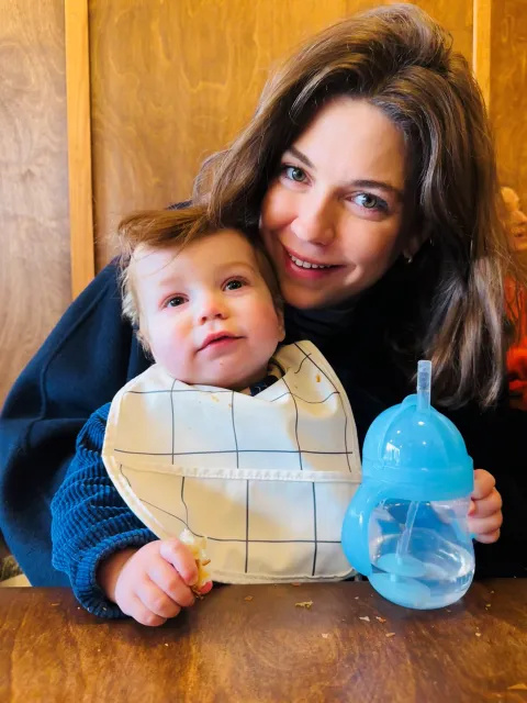 Tansy and Atlas looking at the camera. Atlas is older and wearing a bib and Tansy is smiling. 