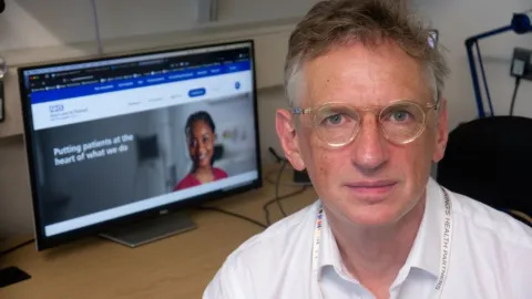 Photo of Professor James Spicer looking at the camera, with his computer screen in the background