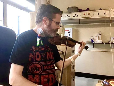 Dave playing the violin while in hospital
