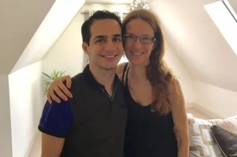 Ali, in a black top, standing next to former colleague Sonia, also in a black top. Ali donated his kidney to Sonia.