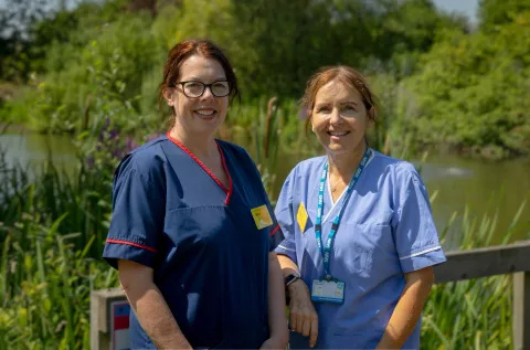 Emma and Charis standing together in front of a lake