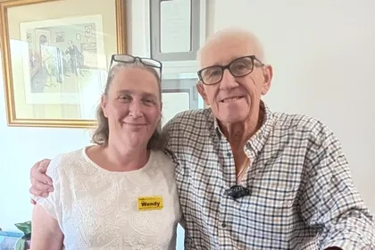 A patient and his rehabilitation support worker standing in their home