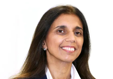 A portrait shot of the Trust's Chief Nurse, Avey Bhatia. She is smiling and wearing a white shirt and navy jacket.