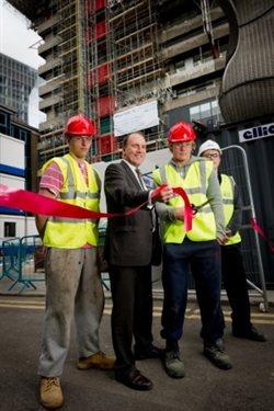 MP Simon Hughes, with local apprentices in high-vis tops and hard hats, cutting a ribbon to launch the Guy's Tower re-cladding scheme.