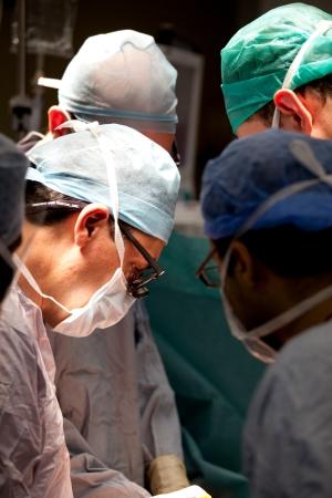 Headshot of 4 surgeons performing an operation