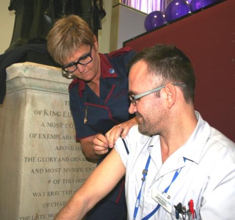 Eileen gives a flu jab to a member of staff