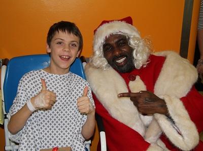 Idris Elba dressed as Father Christmas with patient Ryan Carter