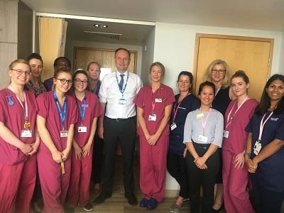 NHS England chief executive posing with midwives