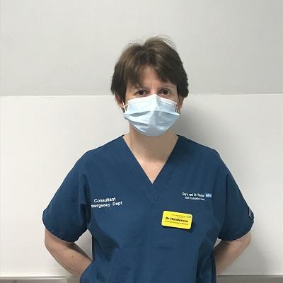 Dr Katherine Henderson is wearing blue scrubs and a face mask