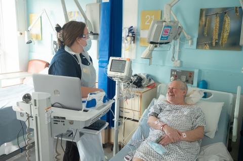 nurse caring for patient on ward