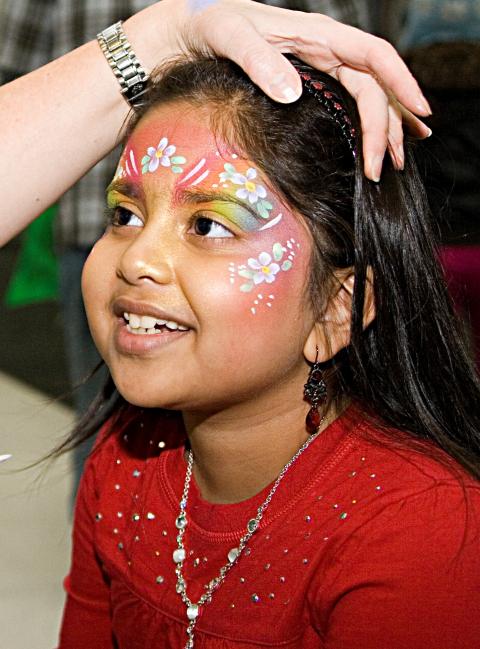 Young girl having her face painted